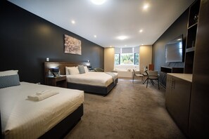 Minibar, escritorio, cortinas blackout y tabla de planchar con plancha 