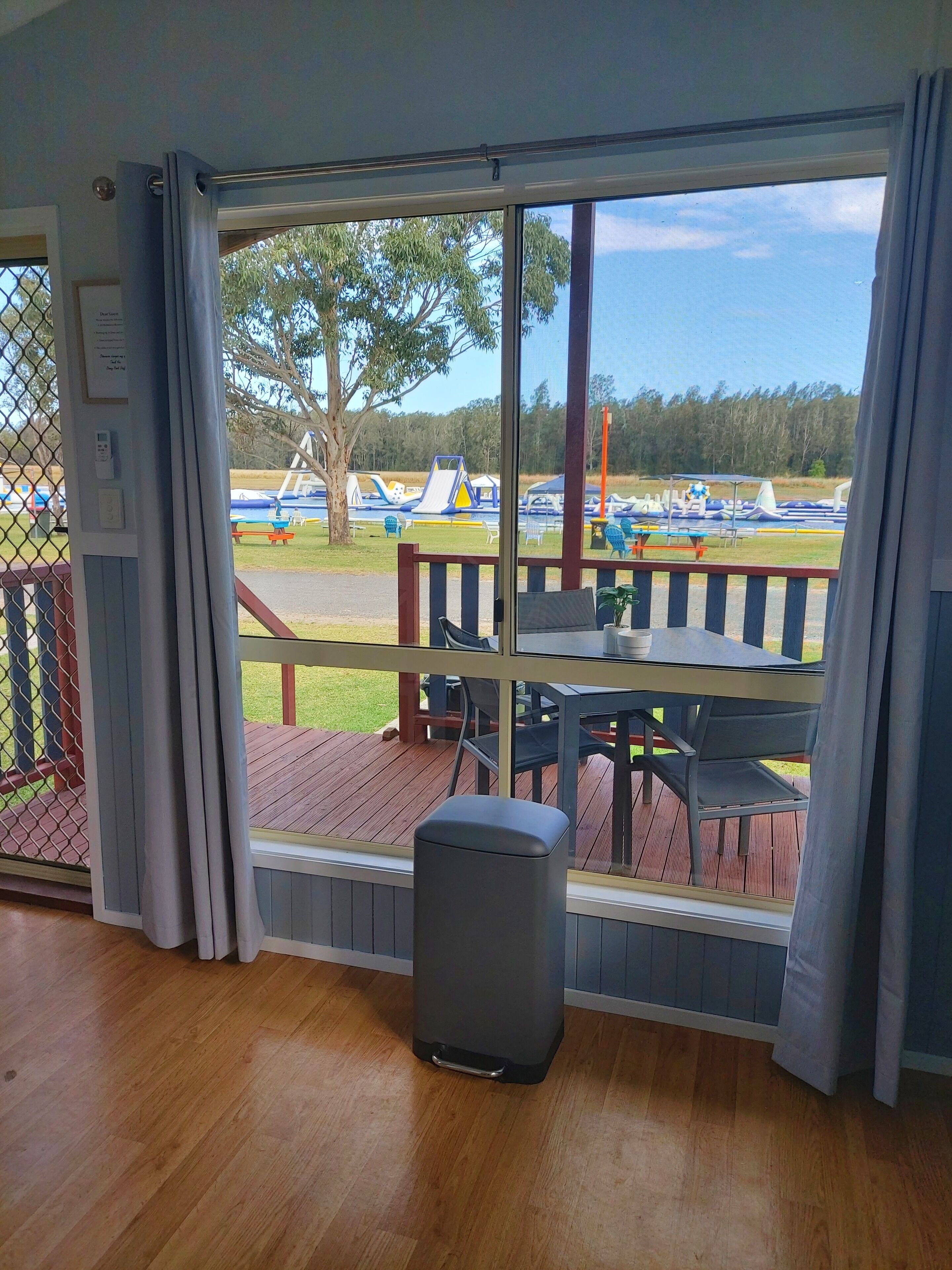 Una habitación con un amplio ventanal que da a un parque infantil con toboganes y estructuras de juego.
