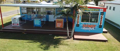A small outdoor coffee kiosk with a blue and white color scheme, featuring a sign for 'Stoney Aqua Park' and a 'Coffee' sign.