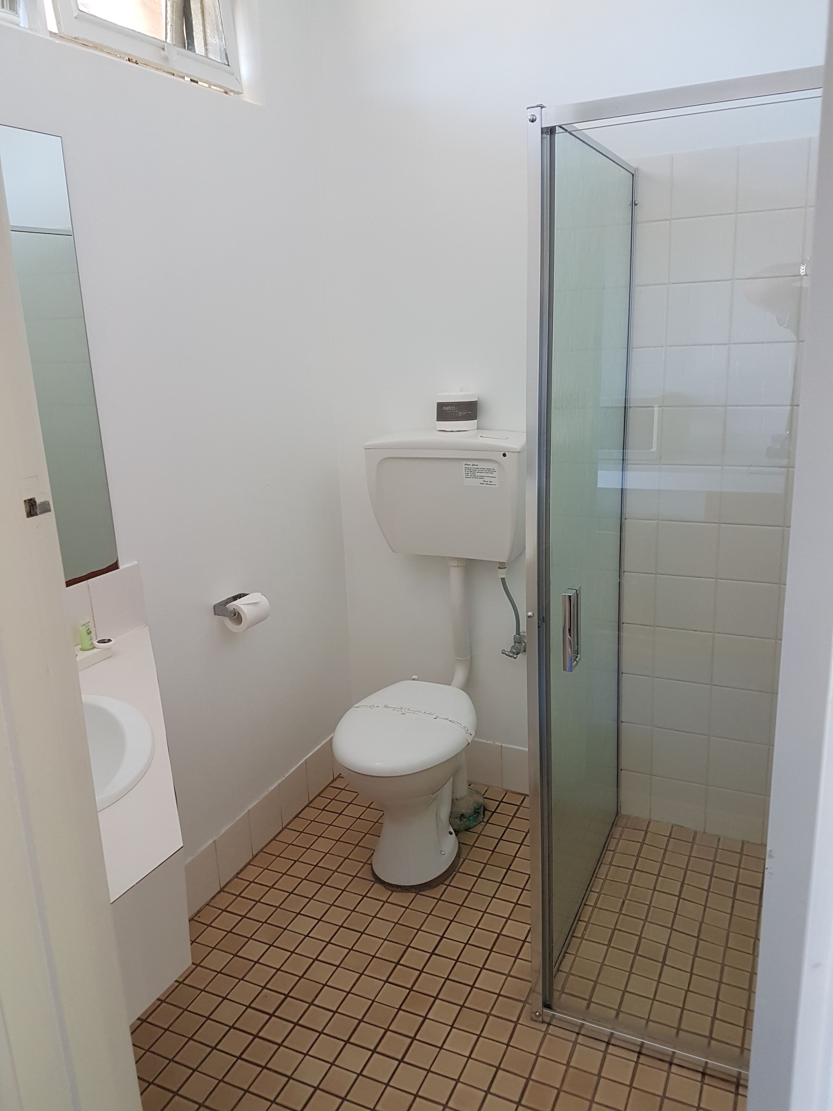A bathroom with a toilet, a sink, and a glass shower enclosure.