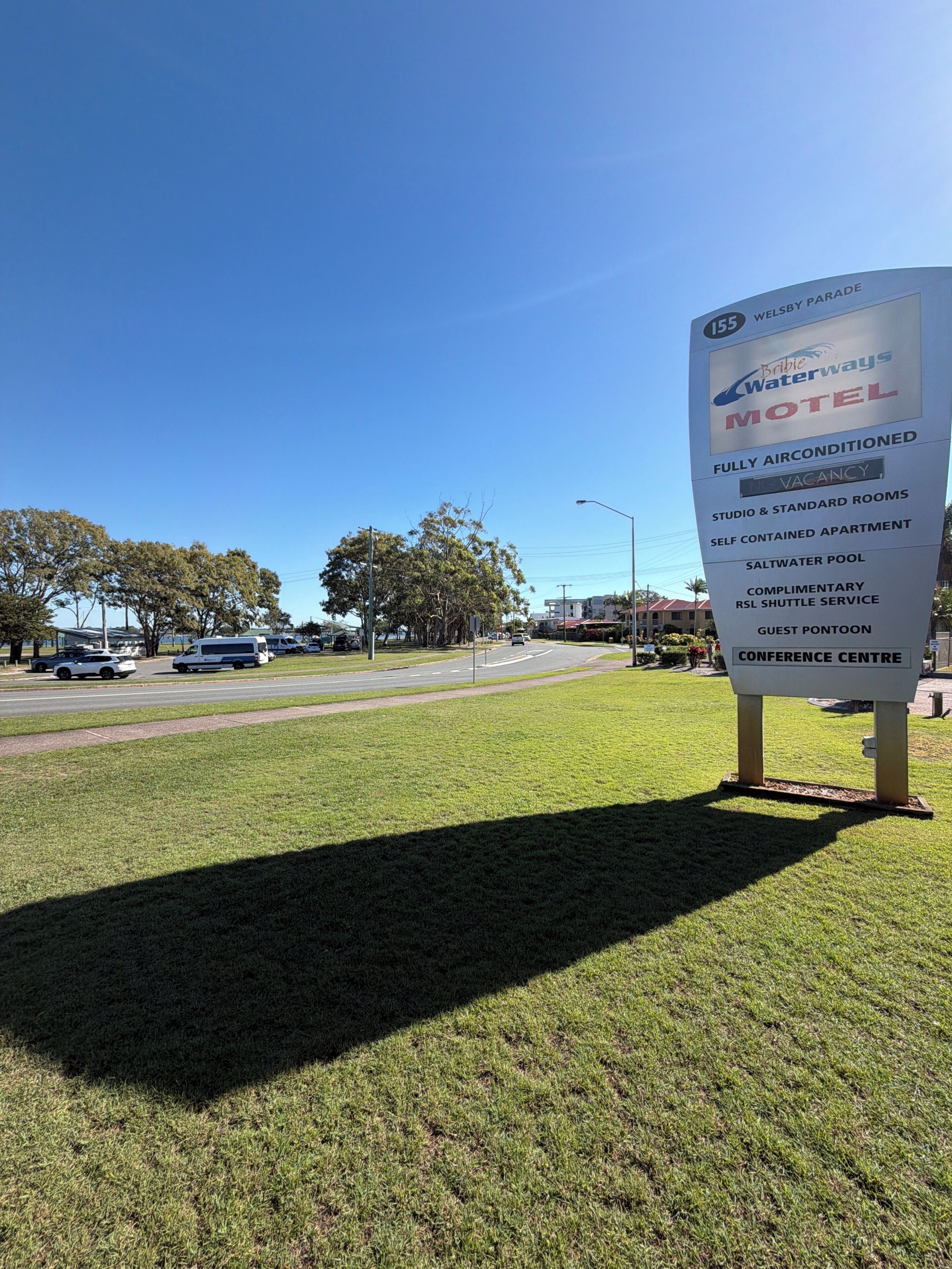 A sign for Bribie Waterways Motel, listing amenities such as fully airconditioned rooms, a saltwater pool, and a conference center.