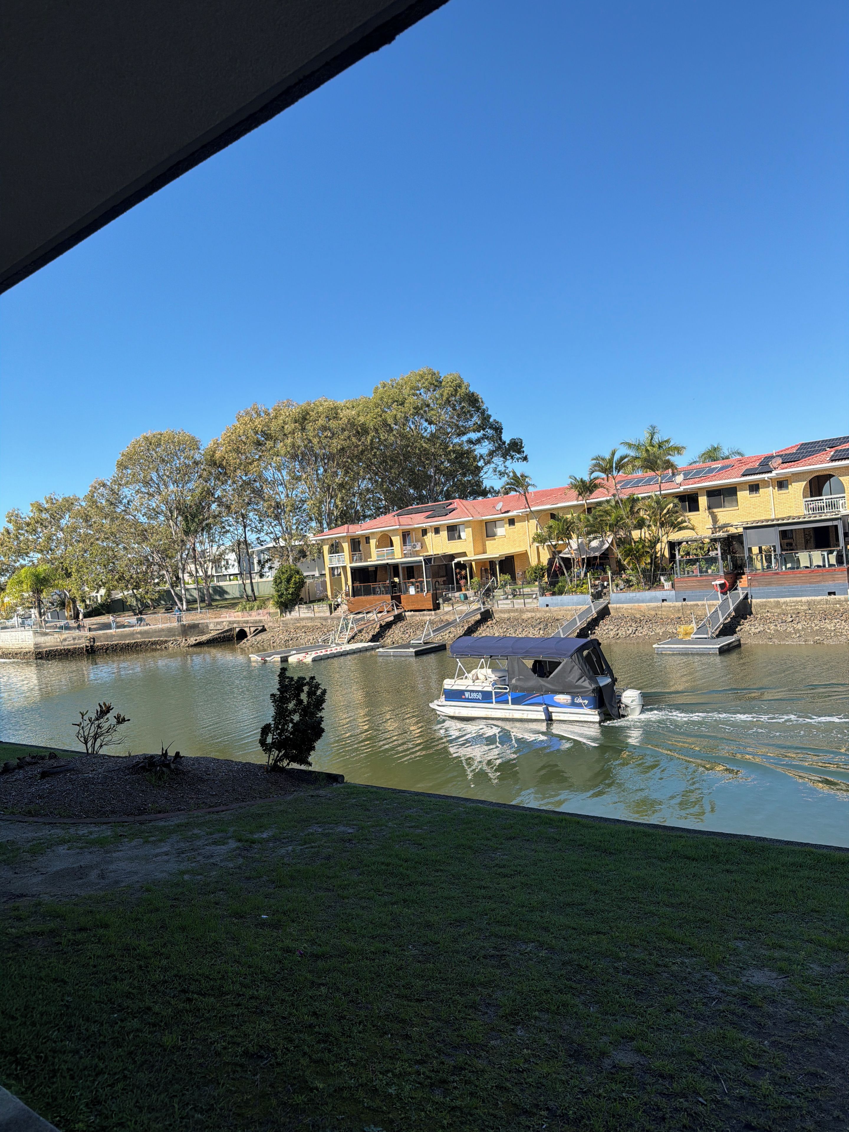 Un río con barcos, un puente y edificios al fondo.