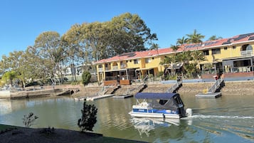 Un río con barcos, un puente y edificios al fondo.