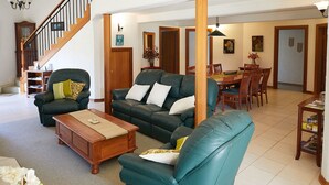 A spacious living room with a staircase, a dining area, and a bookshelf. - A View of Mt Warning B&B (Dum Dum)