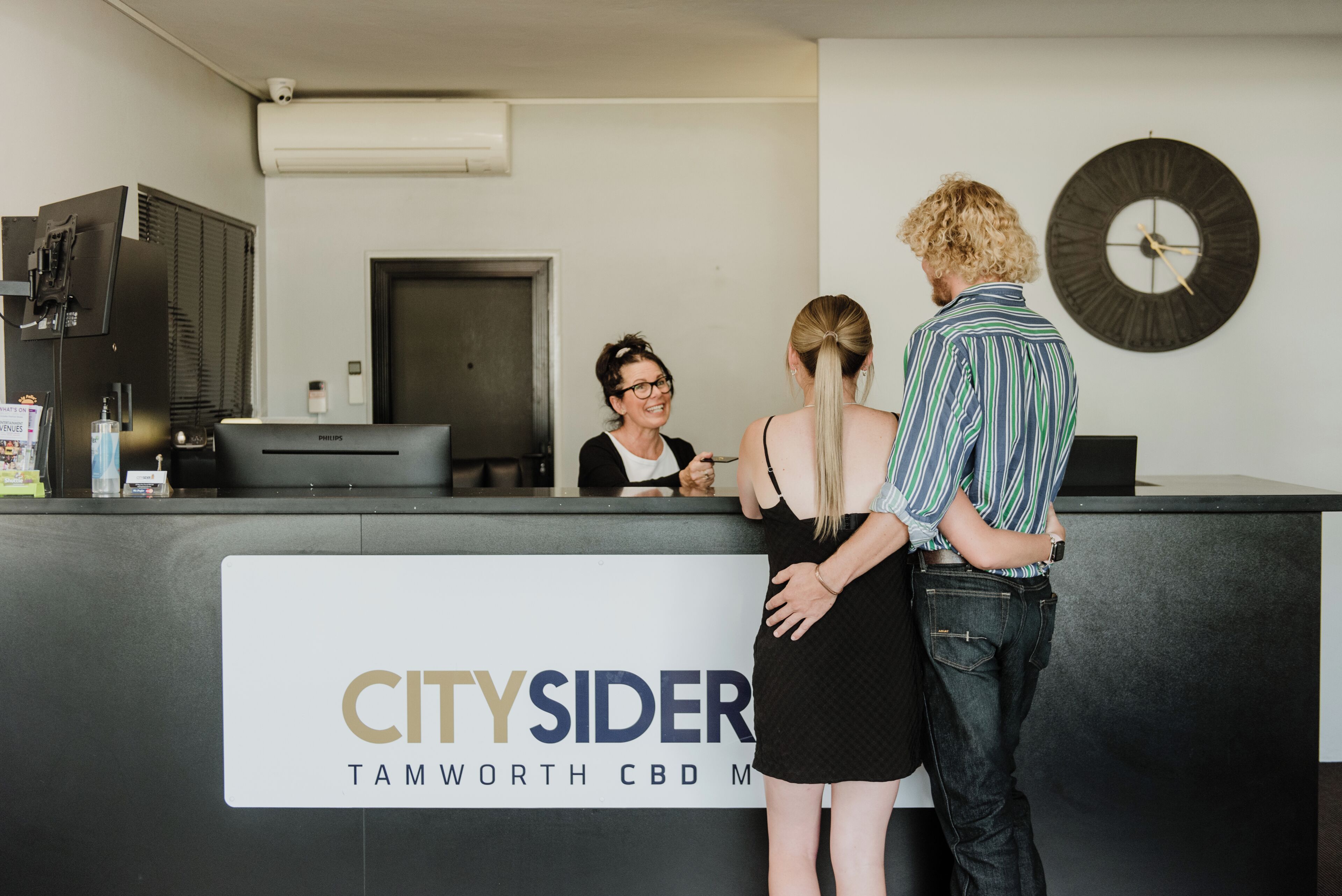 Un mostrador de recepción con un letrero que dice 'CITYSIDER TAMWORTH CBD'.