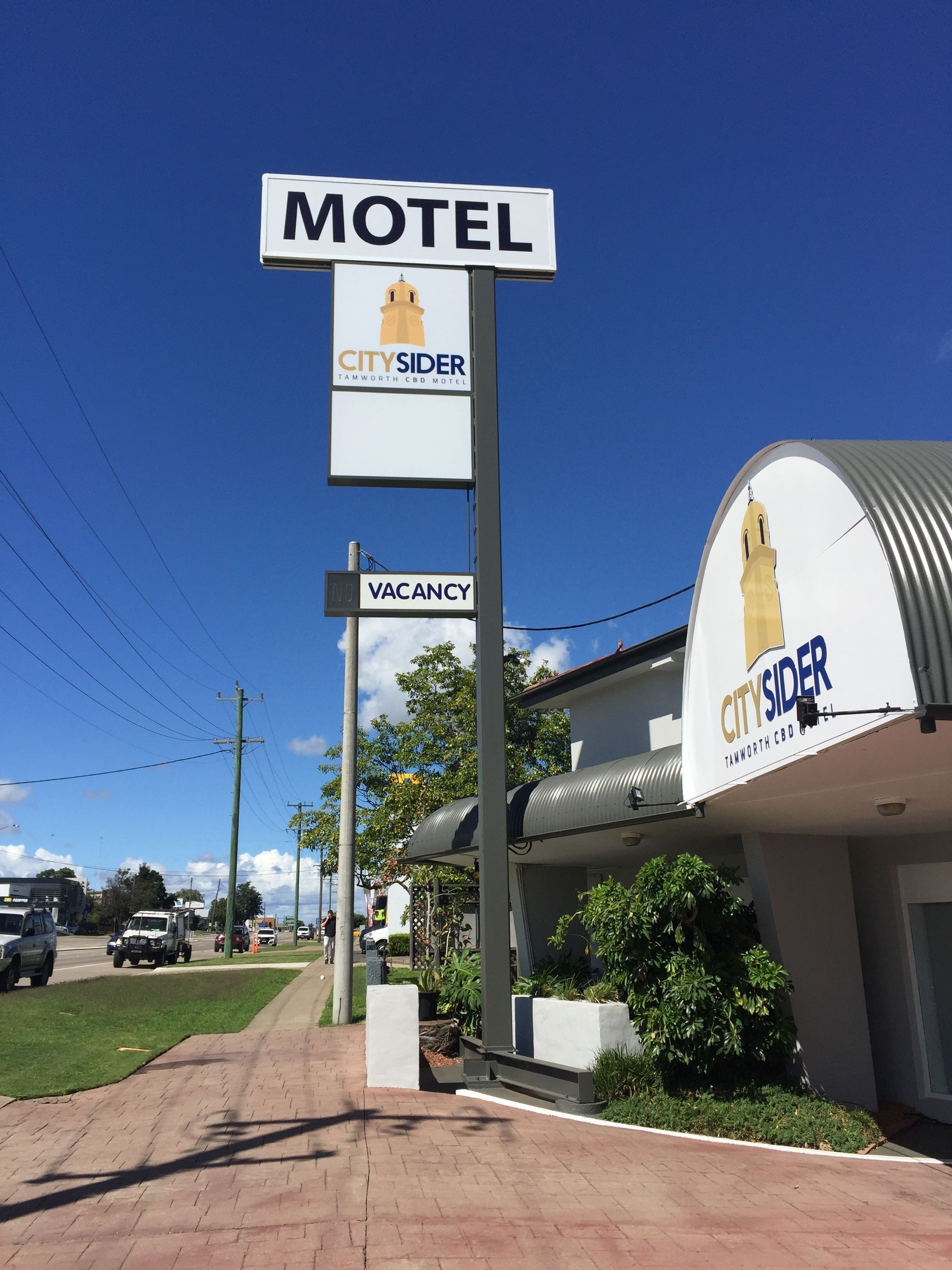 Une enseigne de motel avec le logo « CitySider » et, en dessous, une autre enseigne indiquant « Chambres disponibles ».