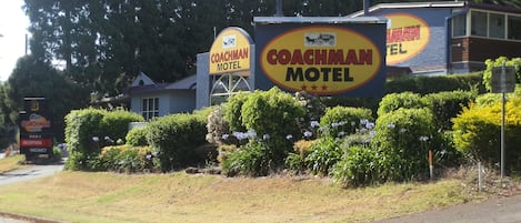 A Coachman Motel sign with a reception and vacancy sign.