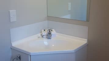 A bathroom with a white sink, a mirror, and a towel rack.