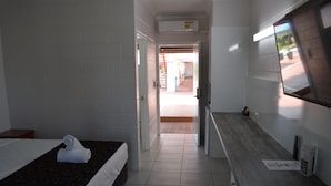 A hotel room with two beds, a wooden counter, and a television. - Monte Carlo Motor Inn (Rosslea)