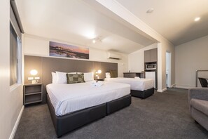 A hotel room with two beds, a desk, a chair, a microwave, and a small kitchenette. - Fern Bay Motel  (Fern Bay)