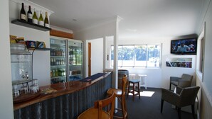A bar area with a counter, seating, and a television. - Fern Bay Motel  (Fern Bay)