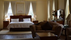 A hotel room with a large bed, a sofa, a small table, and a desk with a lamp. - The Old Parkes Convent (Parkes)