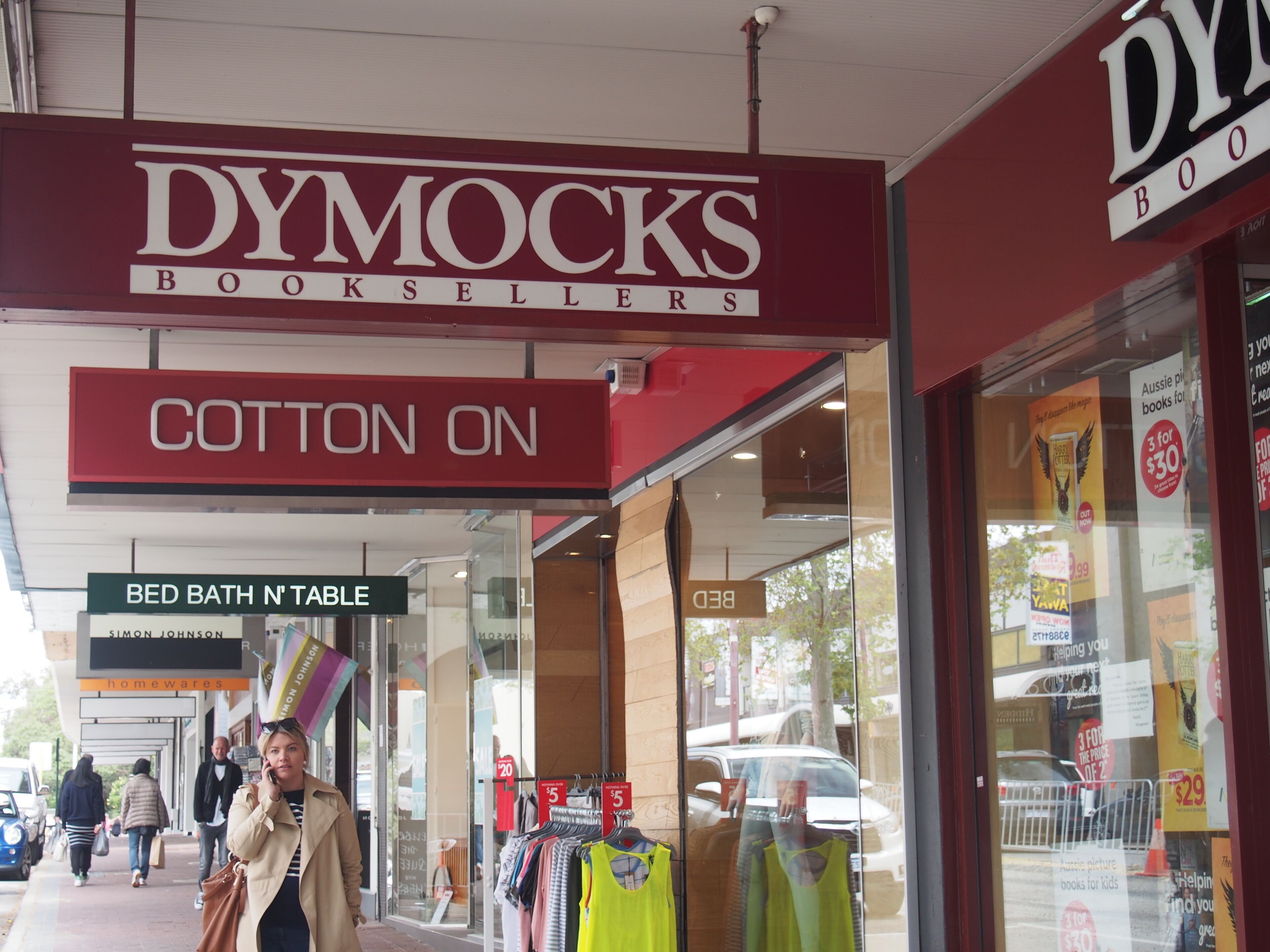 Un escaparate con un llamativo letrero de 'DYMOCKS BOOKSELLERS' y un letrero de 'COTTON ON'.