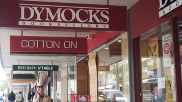 Un escaparate con un llamativo letrero de 'DYMOCKS BOOKSELLERS' y un letrero de 'COTTON ON'.