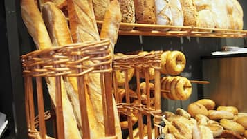 Diversas variedades de panes y pasteles expuestos en estantes y cestas.
