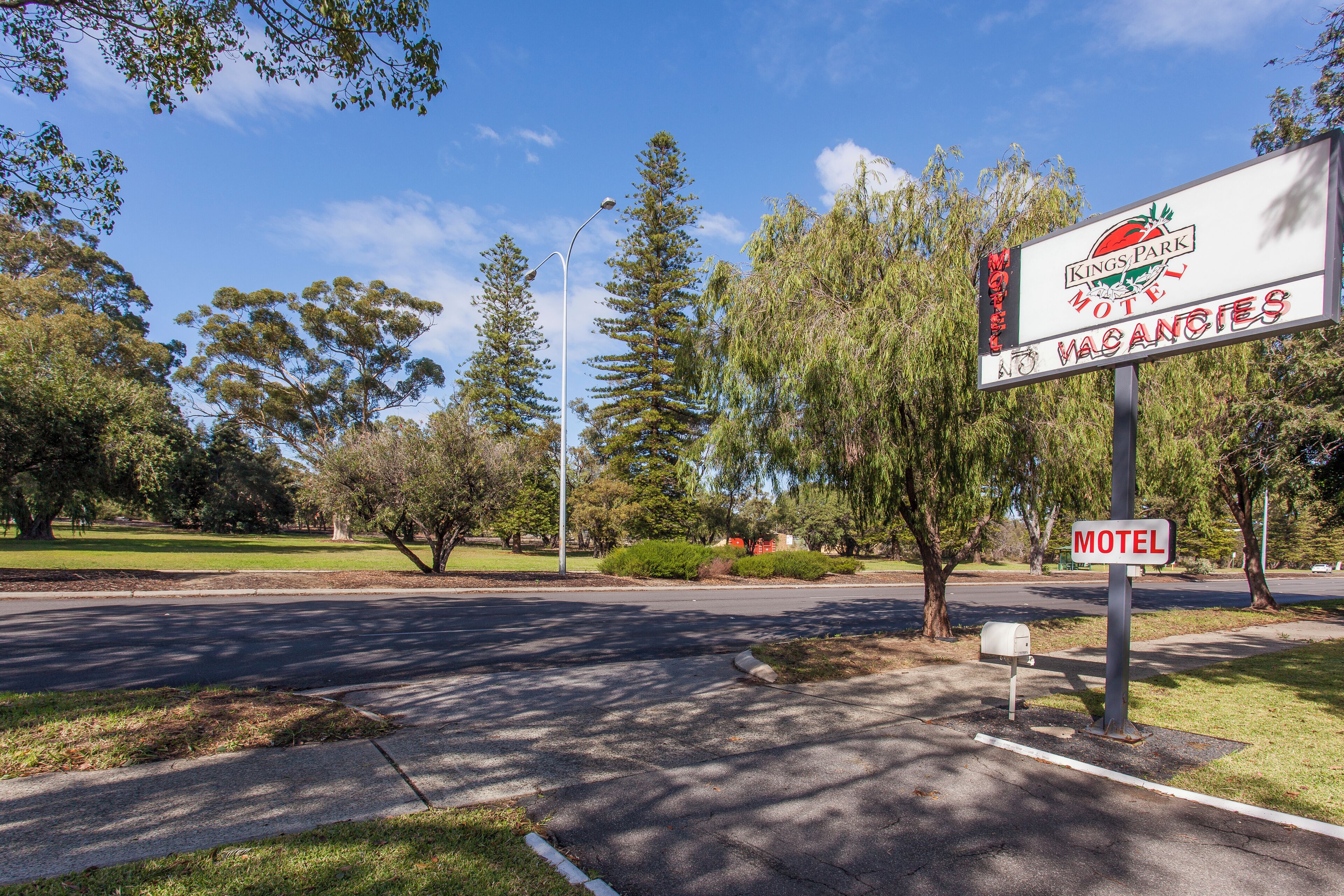 Un panneau indiquant un motel, avec un logo, et portant le nom « Kings Park Motel ».