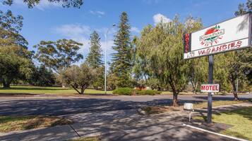 Un panneau indiquant un motel, avec un logo, et portant le nom « Kings Park Motel ».