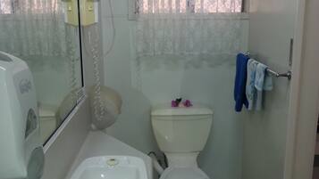 Un baño pequeño con inodoro, lavamanos y espejo.