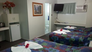 A hotel room with two beds, a small kitchenette, a painting on the wall, and a television mounted above the bed. - Golden Fountain Motel (Allenstown)