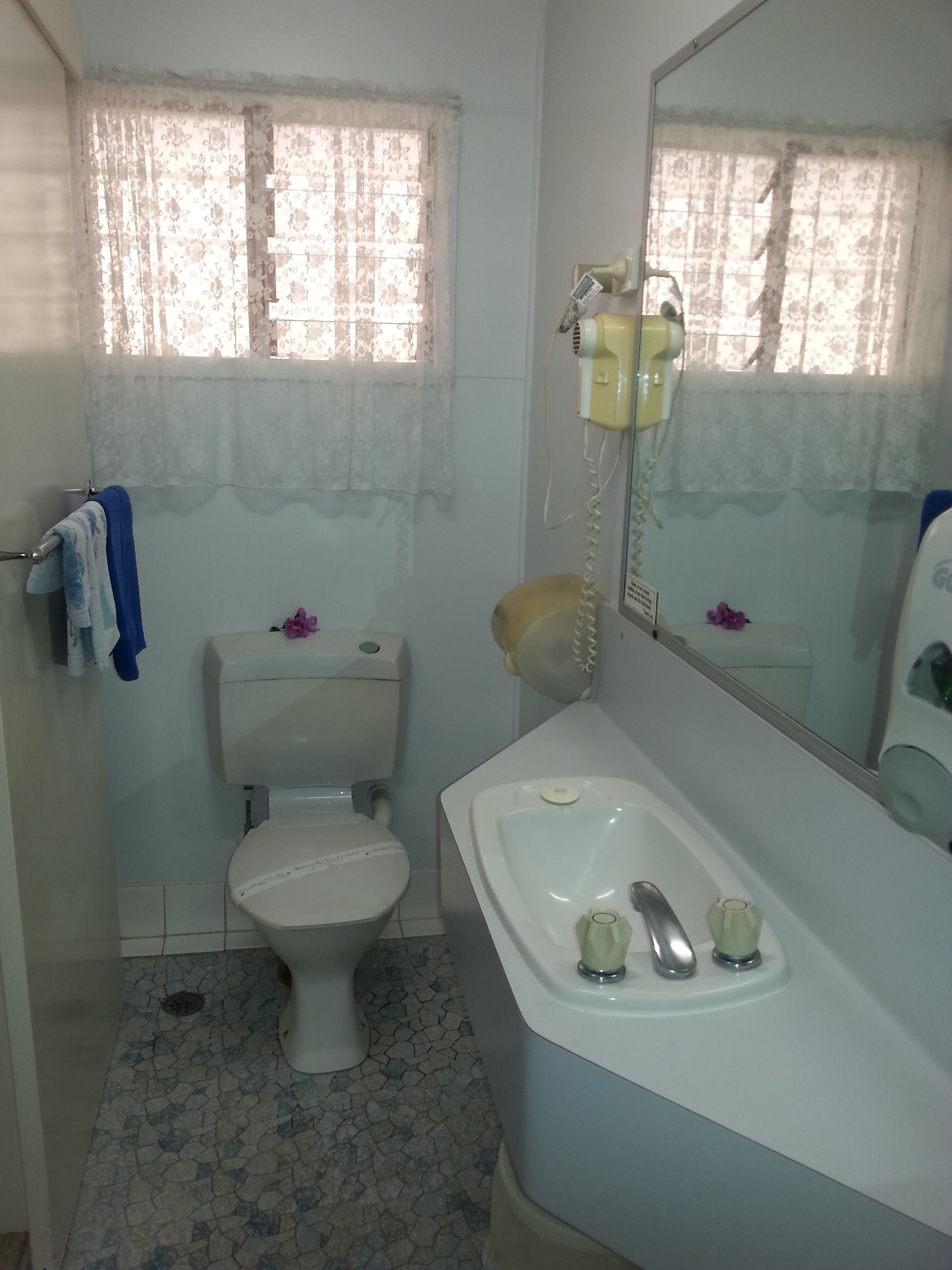Un baño con inodoro, lavabo y espejo.