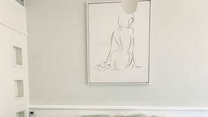 A bedroom with a large bed, fluffy pillows, a wall-mounted artwork, and a ceiling light fixture. - Banana Hotel Motel (Banana)
