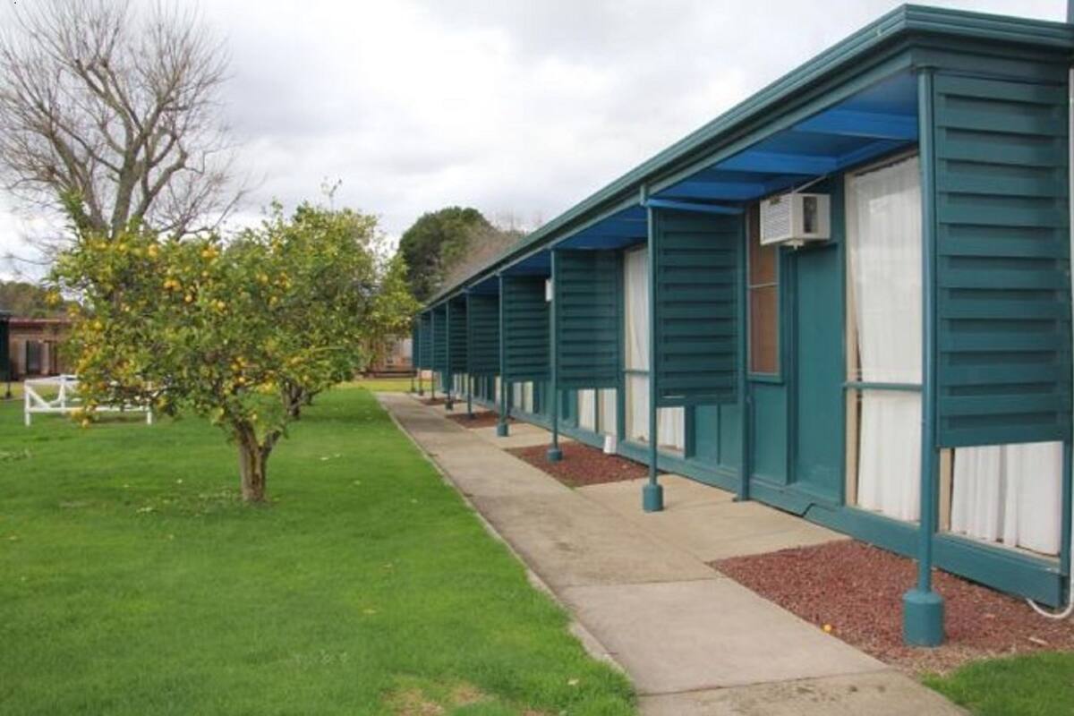 A row of single-story buildings with a flat roof and a covered walkway.