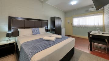 Une chambre d’hôtel avec un grand lit, un bureau et un coin repas.