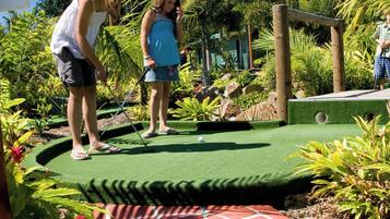 A miniature golf course with a green putting surface and a red patterned area.