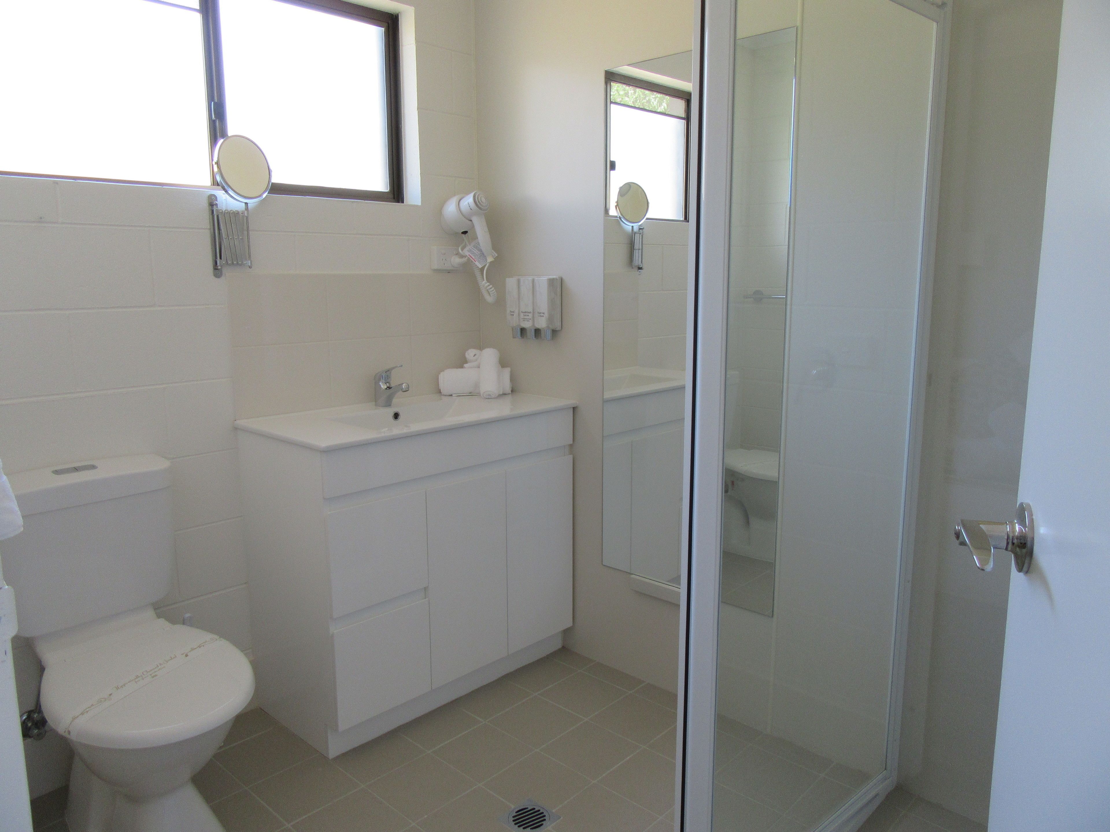 A modern bathroom with a toilet, sink, and shower.