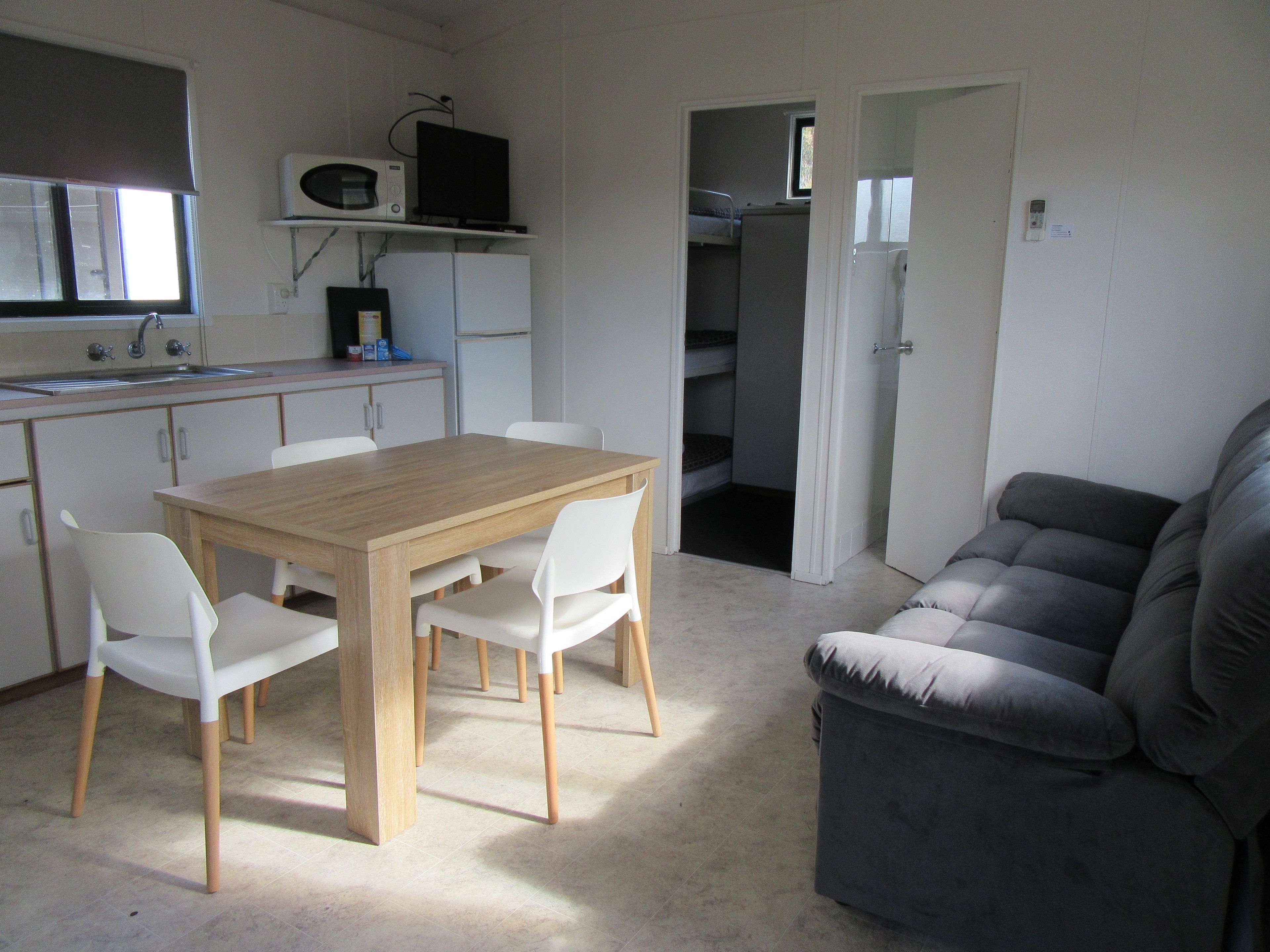A compact living space with a kitchenette, a dining area, and a seating area.