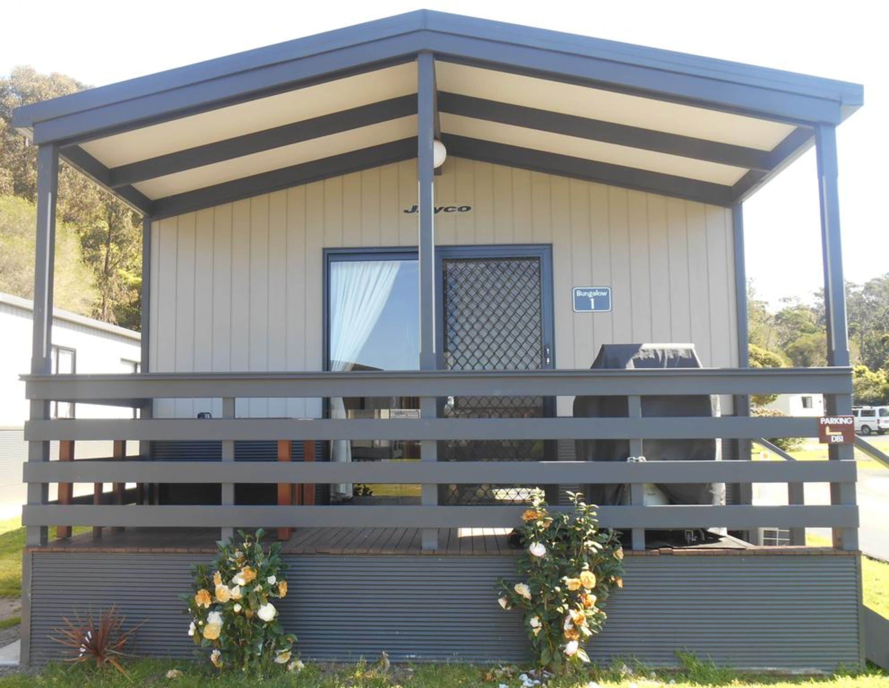 A small, single-story building with a flat roof and a balcony. It has a sign indicating it is a bungalow.