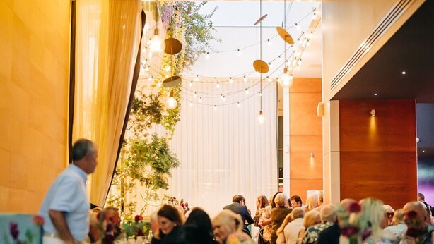 A restaurant interior with tables, chairs, and hanging lights.