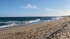 A sandy beach with footprints leading to the water. - Cunningham Shore Motel (Lakes Entrance)