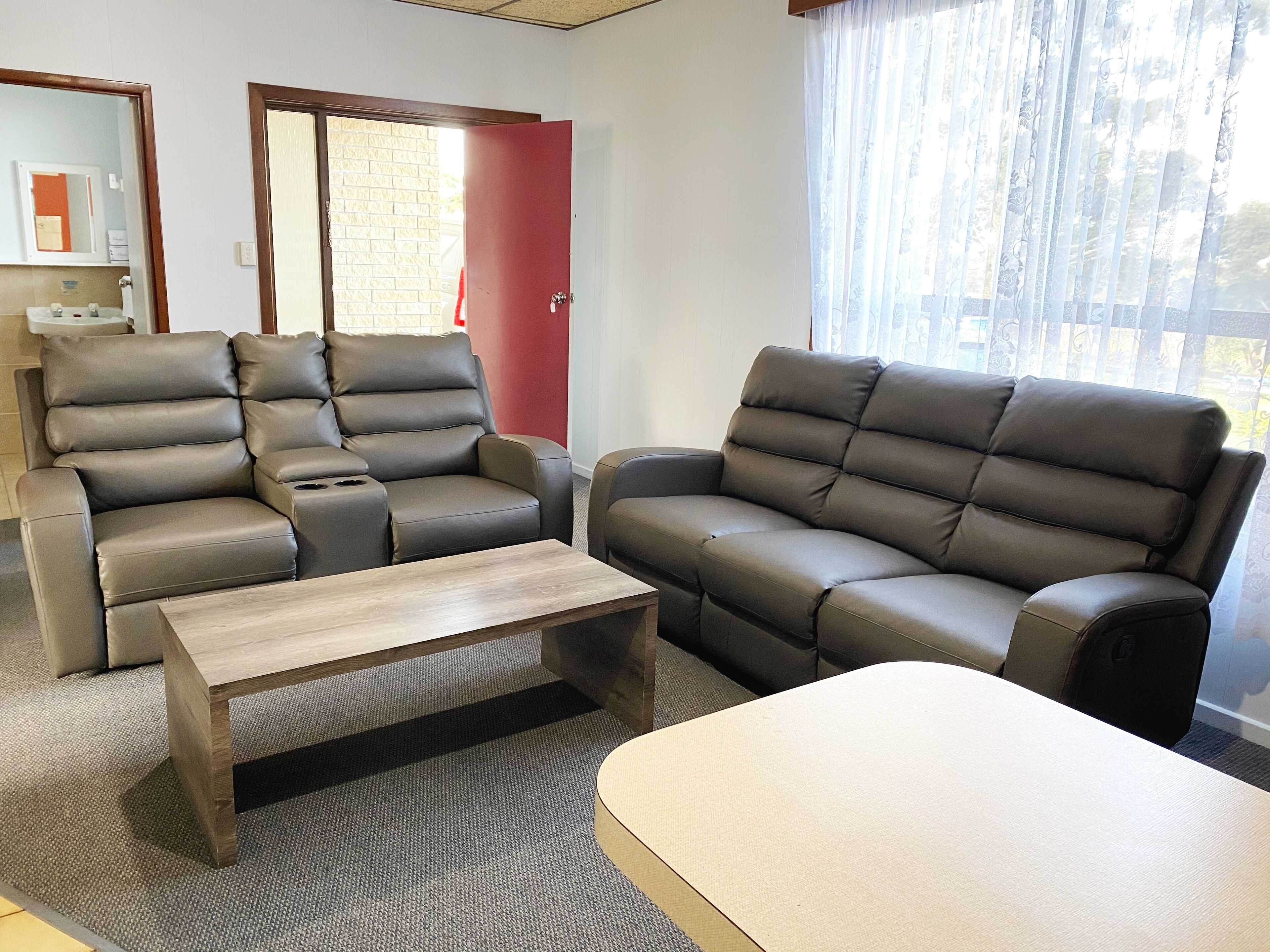 A living room with a sofa, armchair, and coffee table.