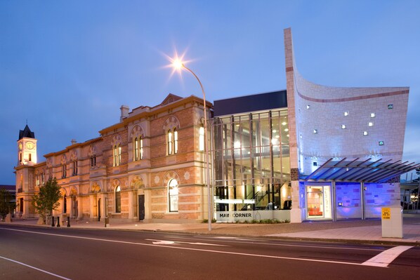 A historic building with a clock tower and a modern glass extension.