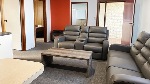A living room with a sectional sofa, a recliner, and a coffee table.