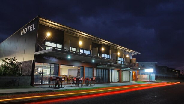 A modern motel with a flat roof, large windows, and a well-lit exterior. - Black Rock Inn (Blackwater)