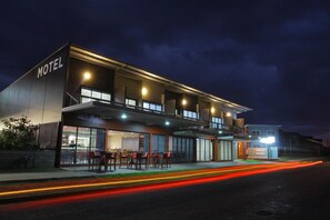 A modern motel with a flat roof, large windows, and a well-lit exterior. - Black Rock Inn (Blackwater)