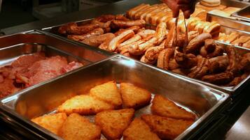 A buffet with various food items including fried items and pastries.