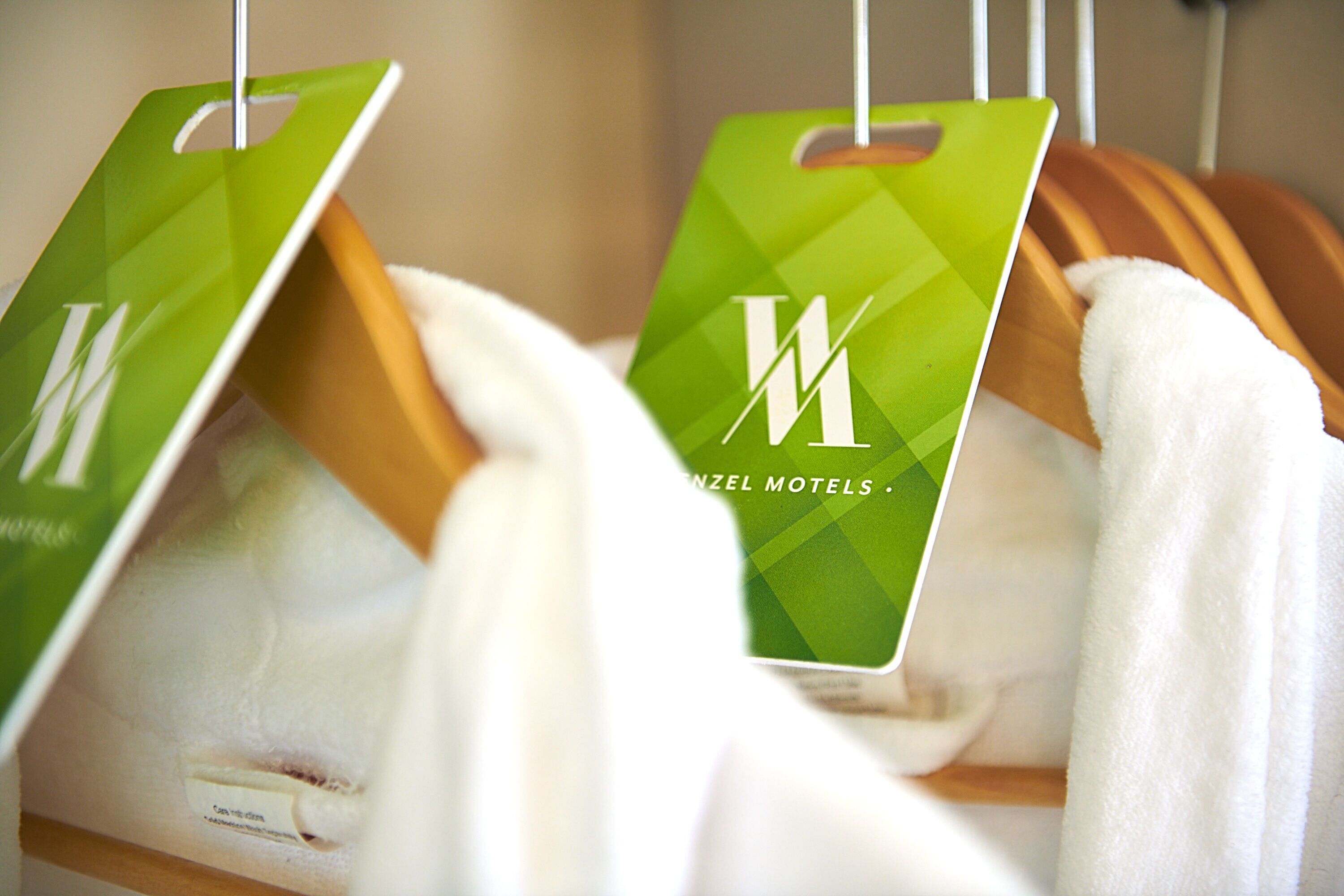 A rack of towels with green tags hanging from it.