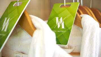 A rack of towels with green tags hanging from it.