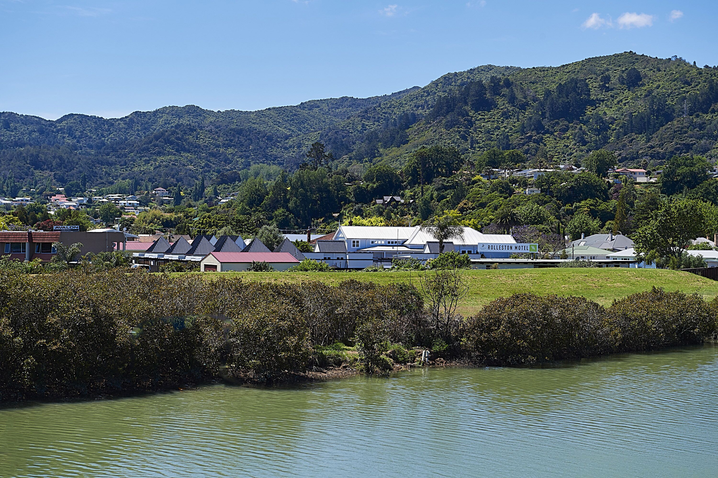 A hotel with a view of a lake and hills.