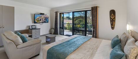 Een moderne hotelkamer met een groot bed, een sofa, een bureau en een televisie.