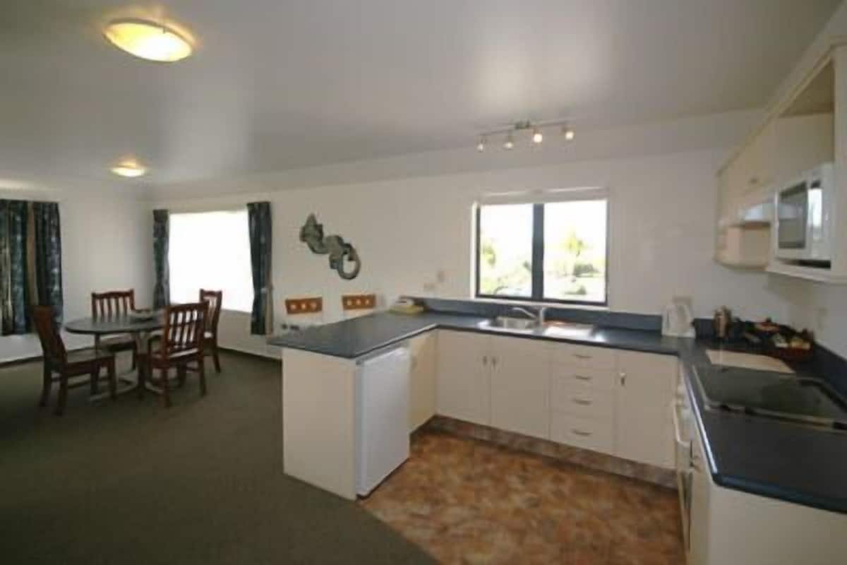 A compact kitchen with a dining area, a small island, and a window providing natural light.