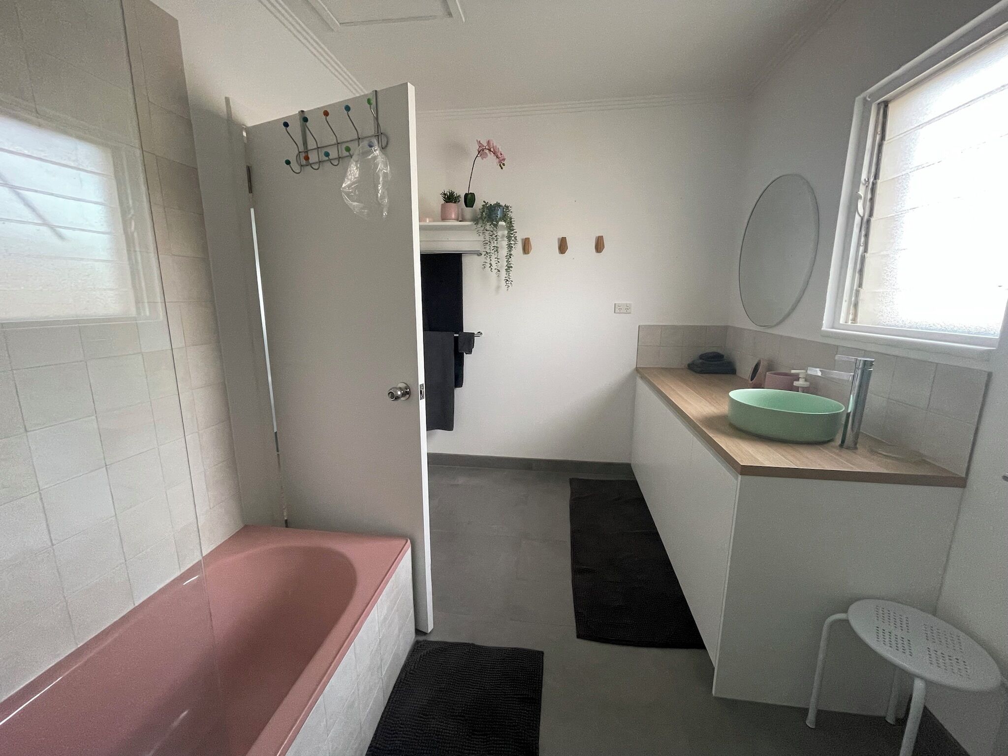 Un baño con bañera, lavamanos, espejo y ventana.