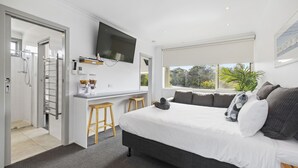 A modern bedroom with a large bed, a desk, and a TV. - Moody's Motel (Blairgowrie)