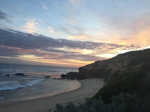 A coastal landscape with a beach, rocky cliffs, and a sunset sky. - Moody's Motel (Blairgowrie)