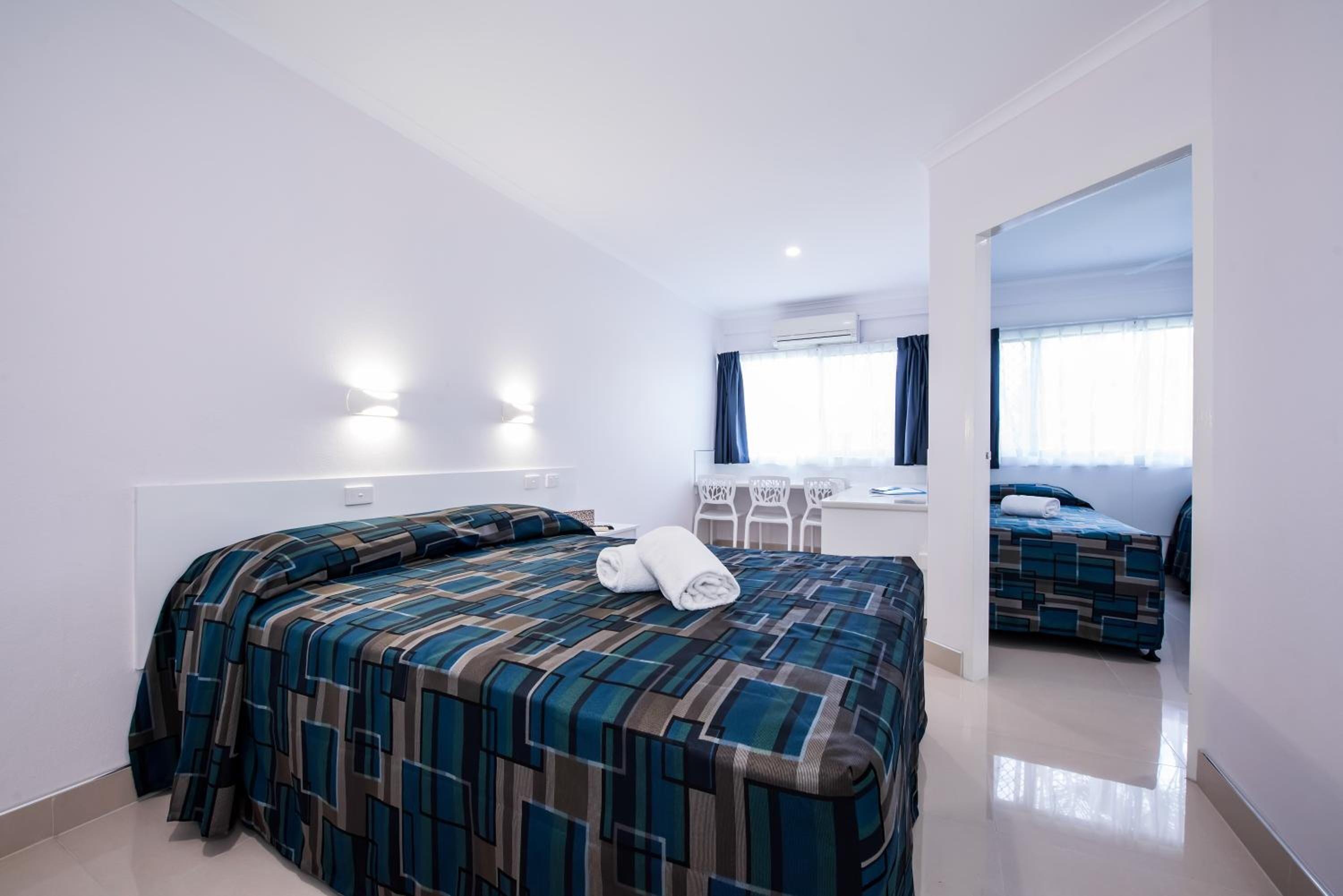 Una habitación de hotel con una cama grande, un escritorio y una silla.