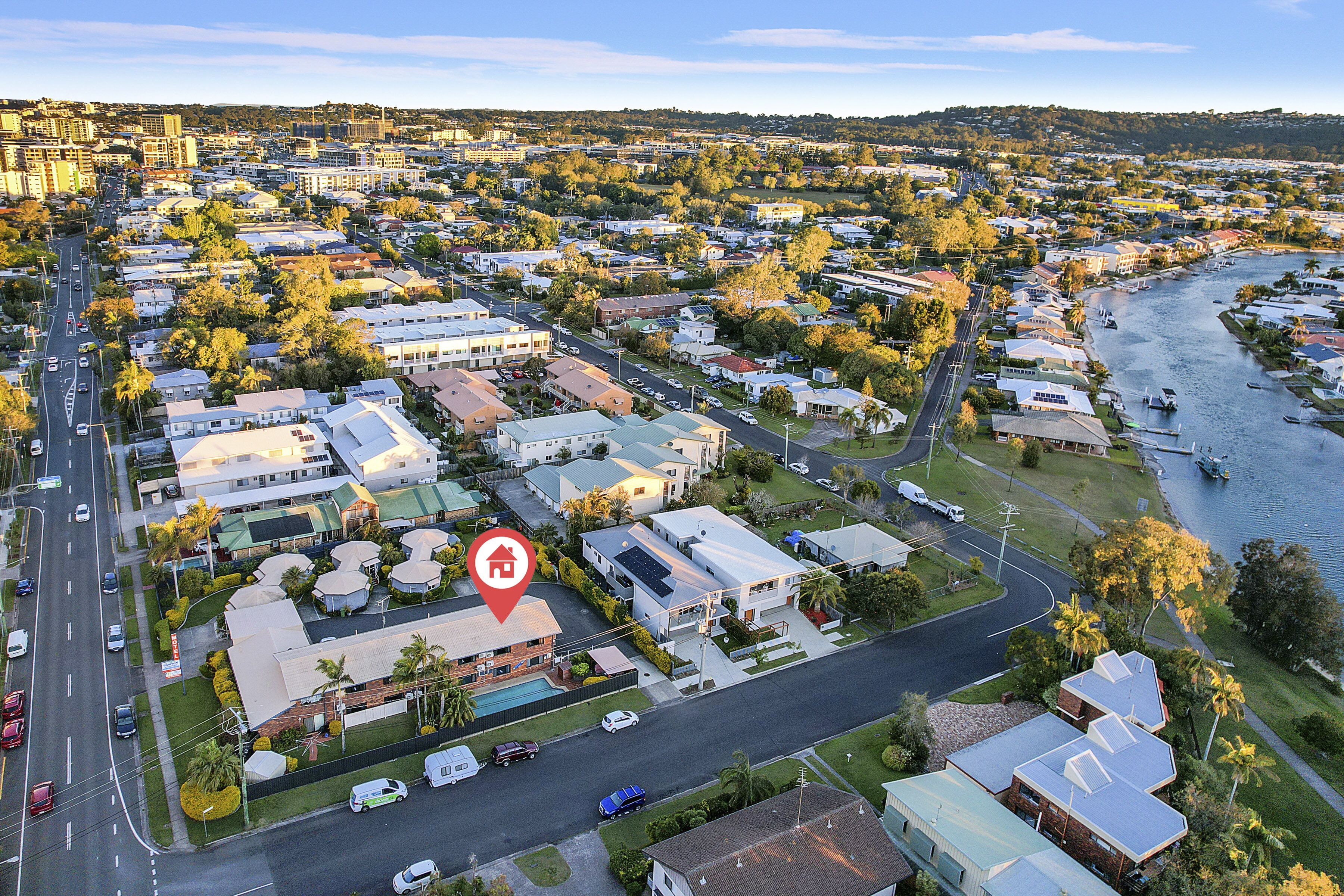 An aerial view of a residential area with houses, a road, and a river.