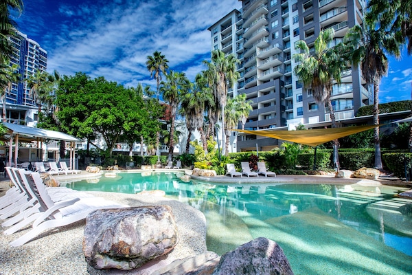 Una piscina al aire libre, sillones reclinables de piscina